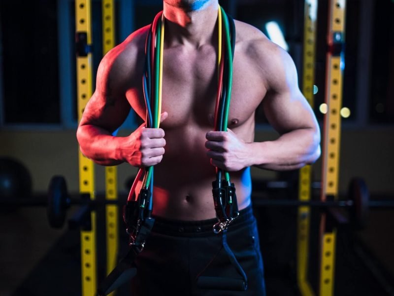 portrait-of-fitness-trainer-with-perfect-abs-holding-resistance-bands-over-neck.jpg